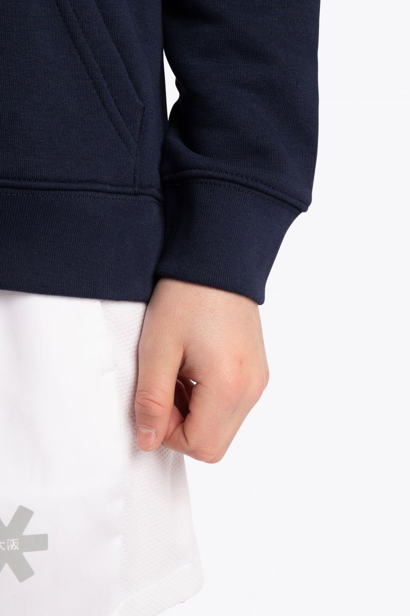 Boy wearing the Osaka kids hoodie in navy with pink star logo. Detail view sleeve