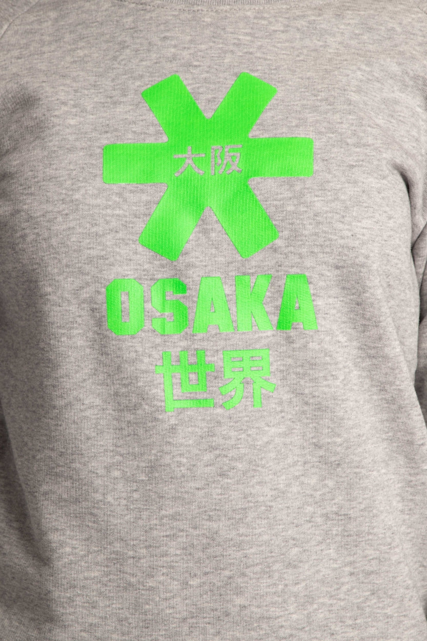 Osaka kids sweater in grey with logo in green. Detail view logo