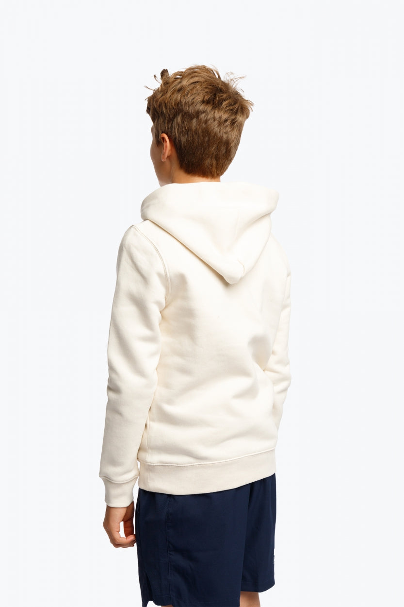 Boy wearing the Osaka kids hoodie in natural raw with college letters in orange and logo in blue. Back view
