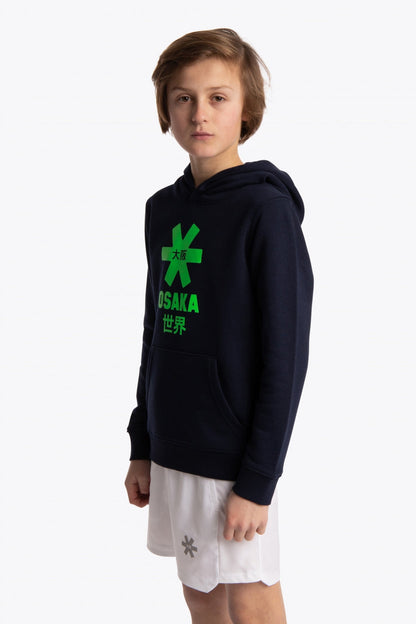 Boy wearing the Osaka kids hoodie in navy with green star logo. Front/side view