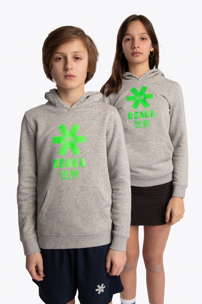 Boy and girl wearing the Osaka kids hoodie in grey with green star logo. Front view
