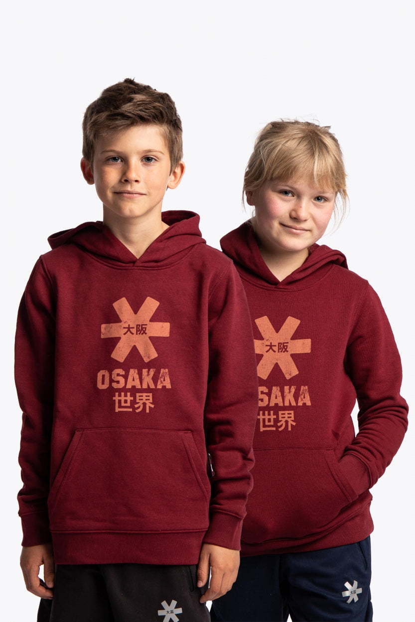 Boy and girl wearing the Osaka kids vintage hoodie in burgundy with logo in orange. Front view