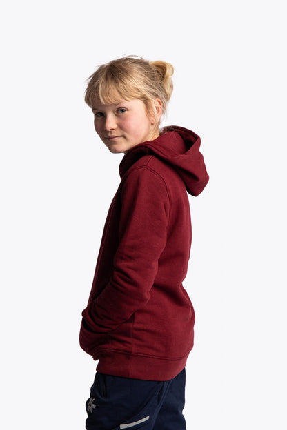 Girl wearing the Osaka kids vintage hoodie in burgundy with logo in orange. Side view