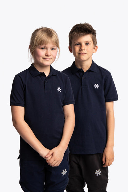 Boy and girl wearing the Osaka kids polo in navy with logo in white. Front view