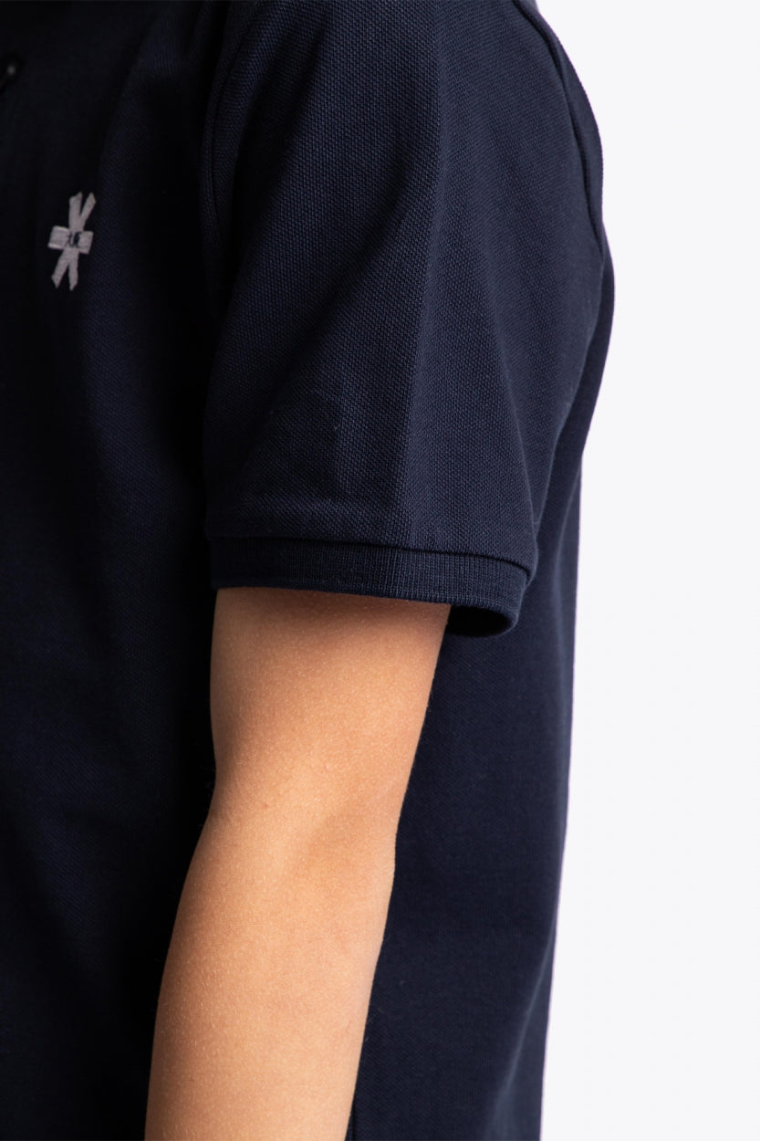 Osaka kids polo in navy with logo in white. Detail view sleeve