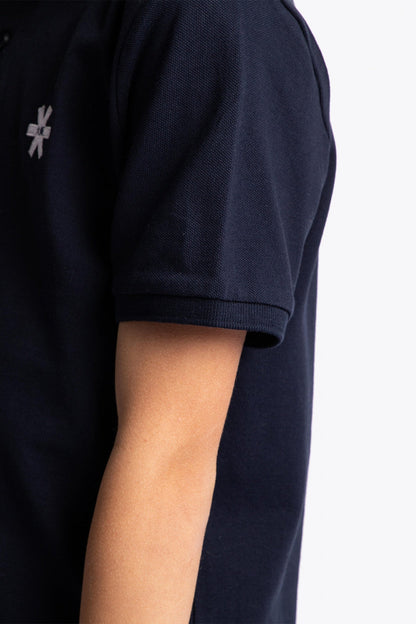 Osaka kids polo in navy with logo in white. Detail view sleeve