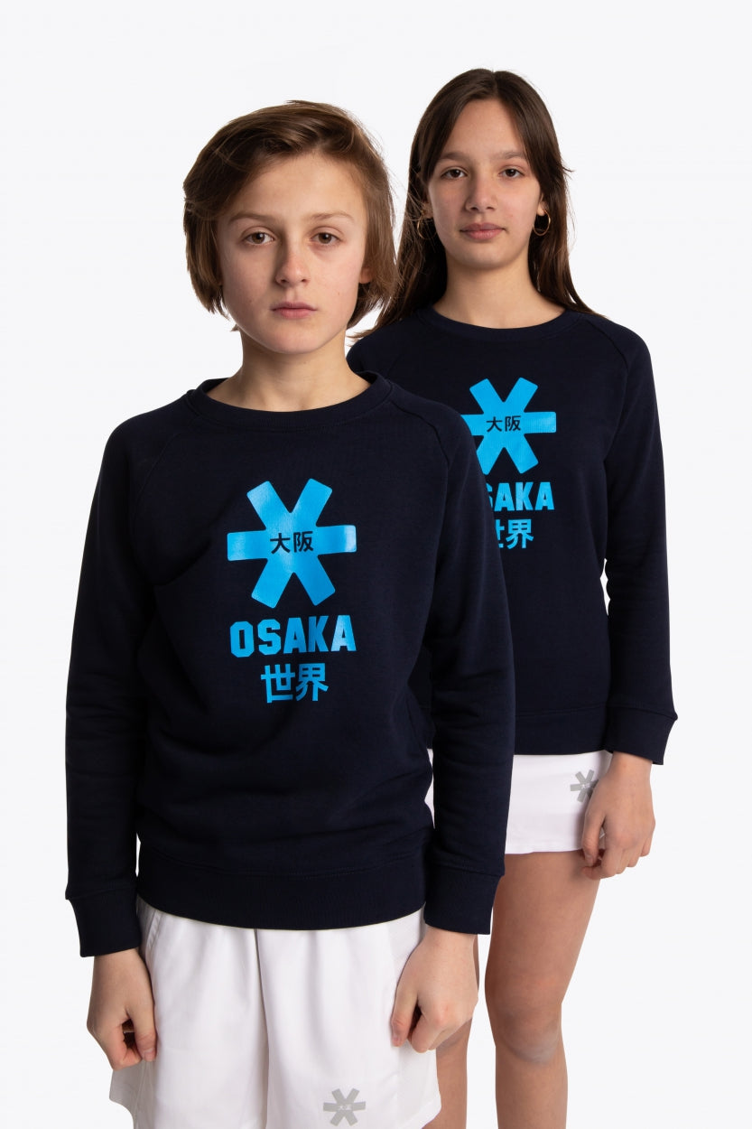 Boy and girl wearing the Osaka kids sweater in navy with logo in blue. Front view