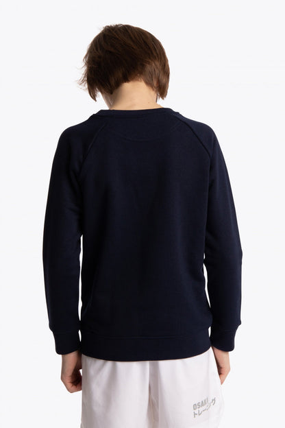 Boy wearing the Osaka kids sweater in navy with logo in blue. Back view