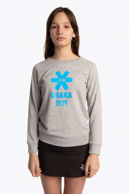 Girl wearing the Osaka kids sweater in grey with logo in blue. Front view