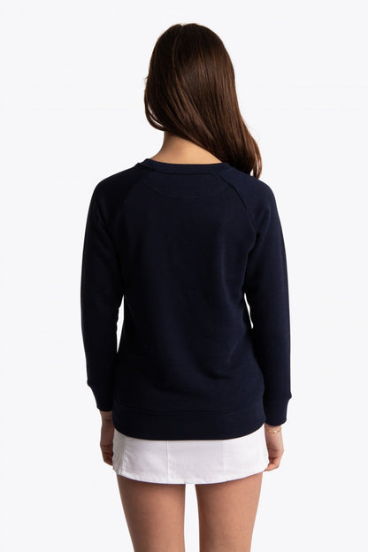 Girl wearing the Osaka kids sweater in navy with logo in green. Back view