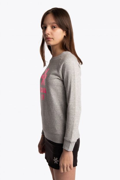 Girl wearing the Osaka kids sweater in grey with pink logo. Side view