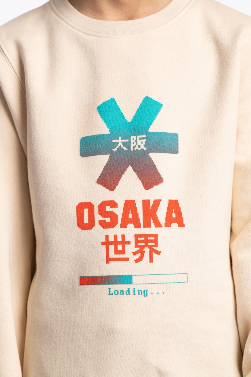 Osaka kids pixo sweater in natural raw with orange and blue logo. Detail view logo