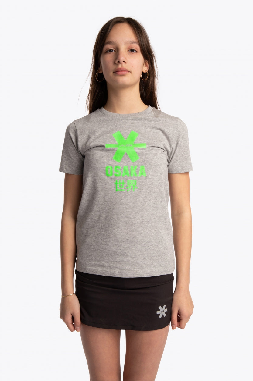 Girl wearing the Osaka kids tee short sleeve grey with logo in green. Front view