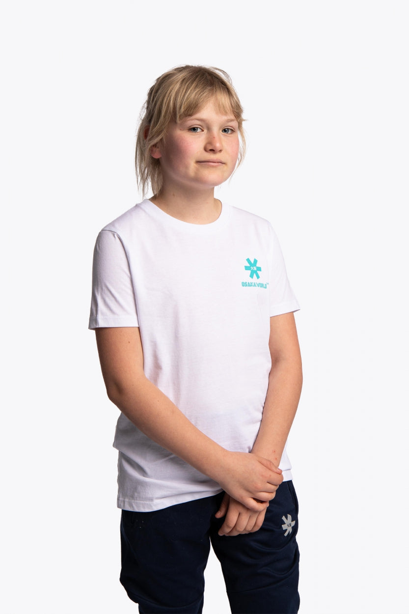 Girl wearing the Osaka kids service games tee short sleeve white with logo in blue. Front view