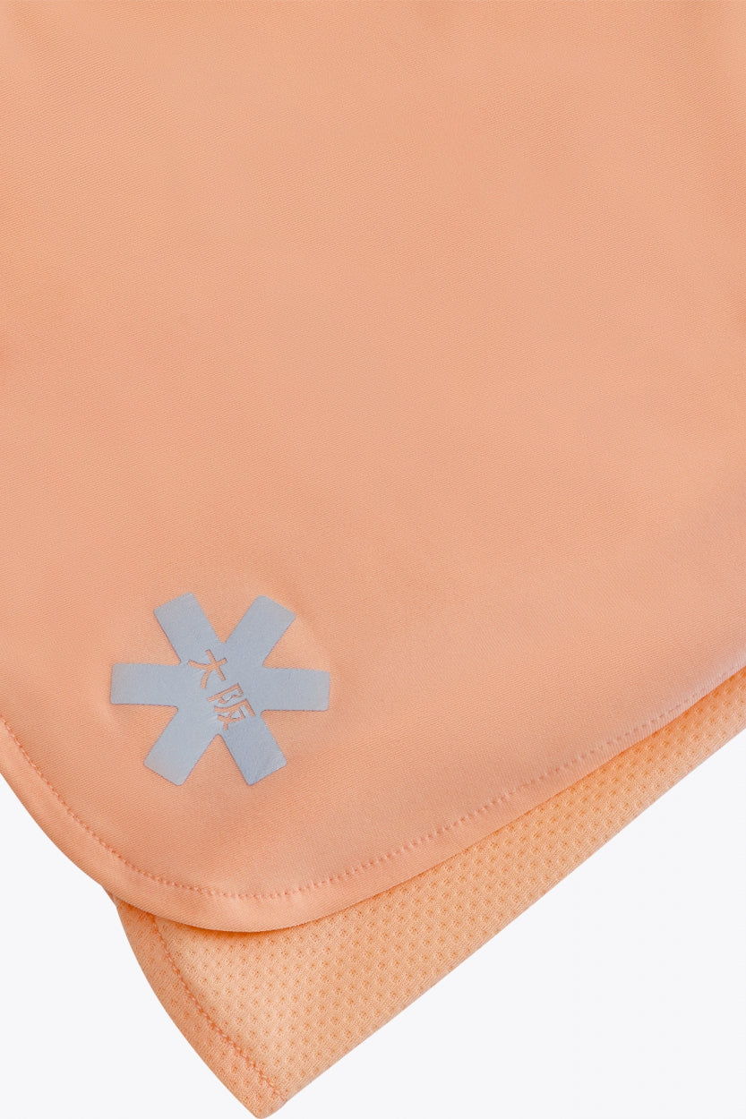 Osaka women ball skort in peach with logo in grey. Detail logo view
