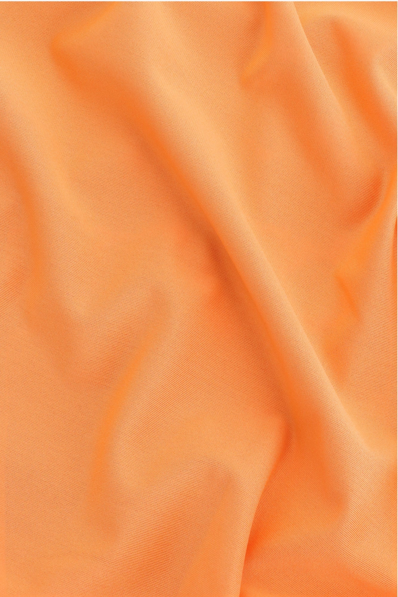 Osaka women ball skort in orange with logo in white. Detail fabric view