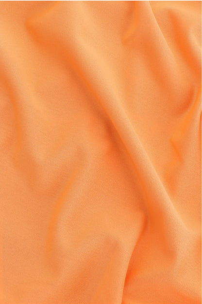 Osaka women ball skort in orange with logo in white. Detail fabric view