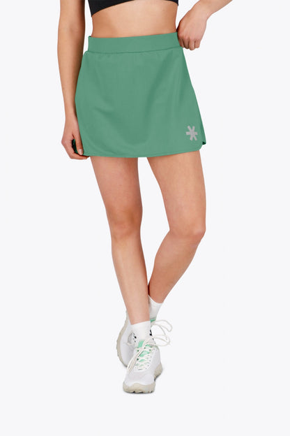 Woman wearing the Osaka women ball skort in green with logo in grey. Front view