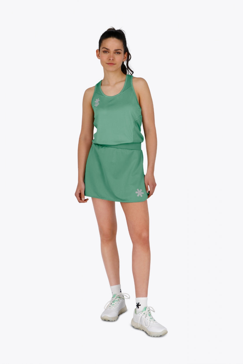 Woman wearing the Osaka women ball skort in green with logo in grey. Front view