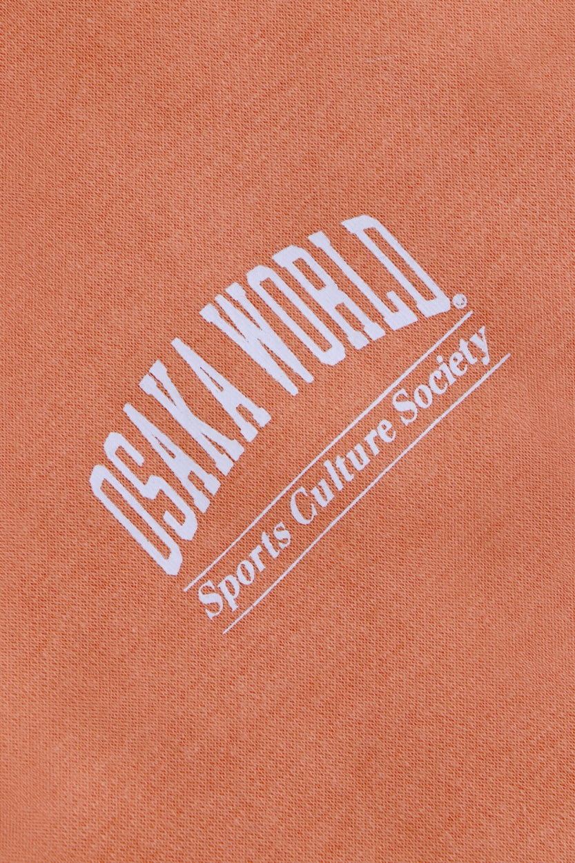 Osaka women half zip sweater in peach with white logo. Detail logo view