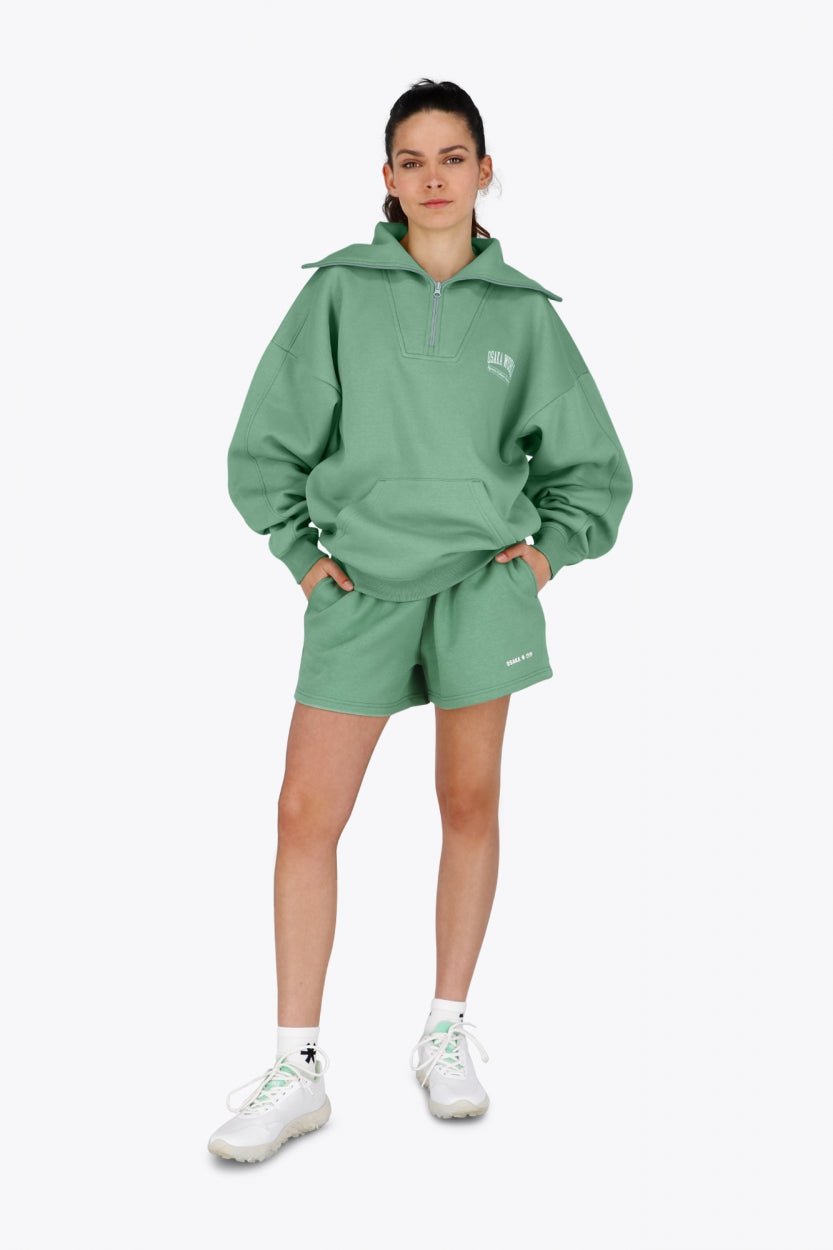 Woman wearing the Osaka women half zip sweater green. Front view