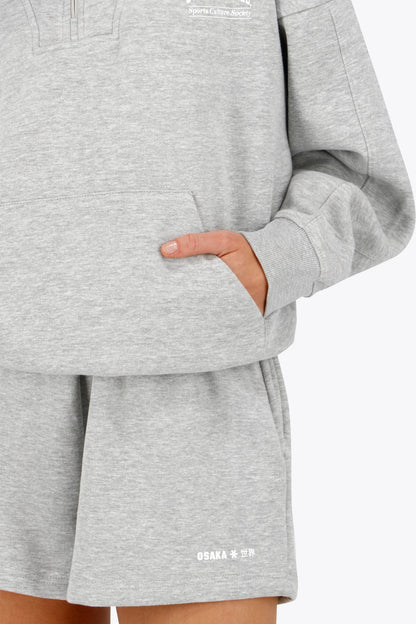 Osaka women half zip sweater in heather grey with white logo. Front detail sleeve view