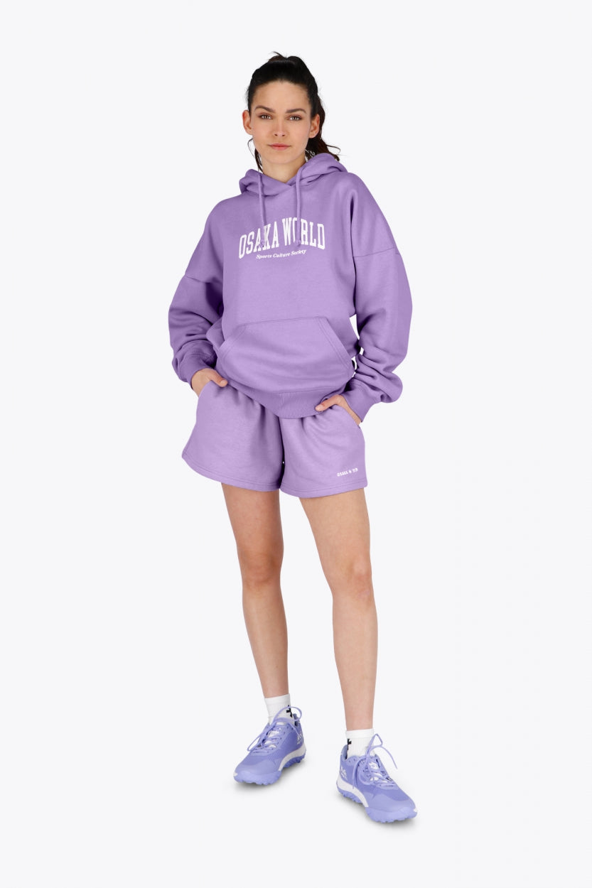 Woman wearing the Osaka women hoodie in light purple with white logo. Front view