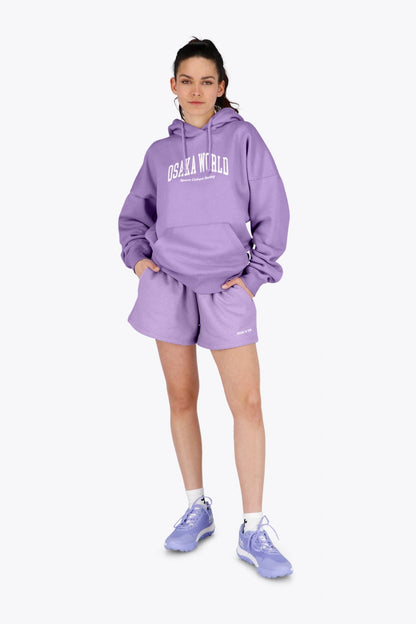 Woman wearing the Osaka women hoodie in light purple with white logo. Front view