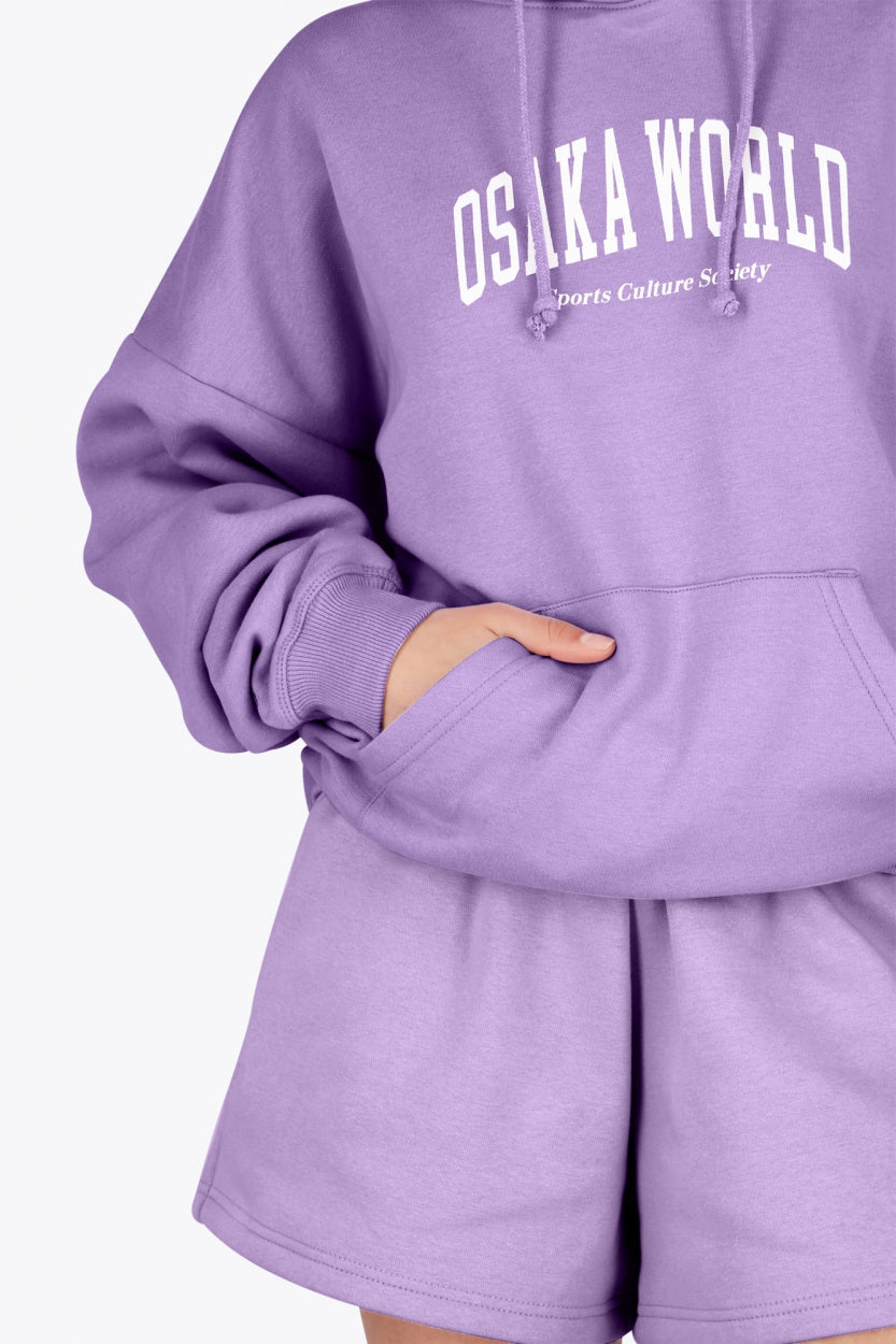 Woman wearing the Osaka women hoodie in light purple with white logo. Front detail sleeve view