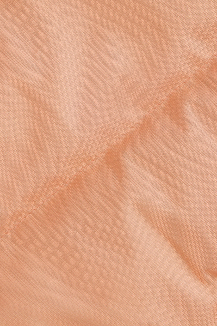 Osaka women padded gilet in peach with grey logo. Front detail fabric view