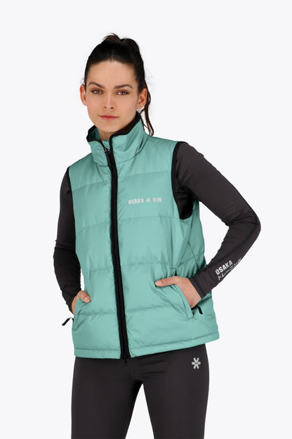 Woman wearing the Osaka women padded gilet in green with grey logo. Front view