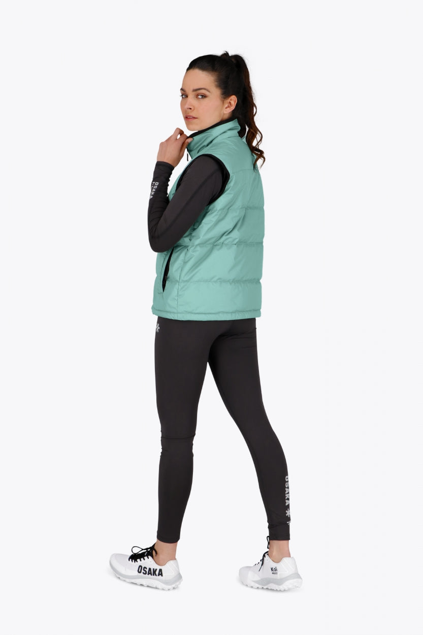 Woman wearing the Osaka women padded gilet in green with grey logo. Back view