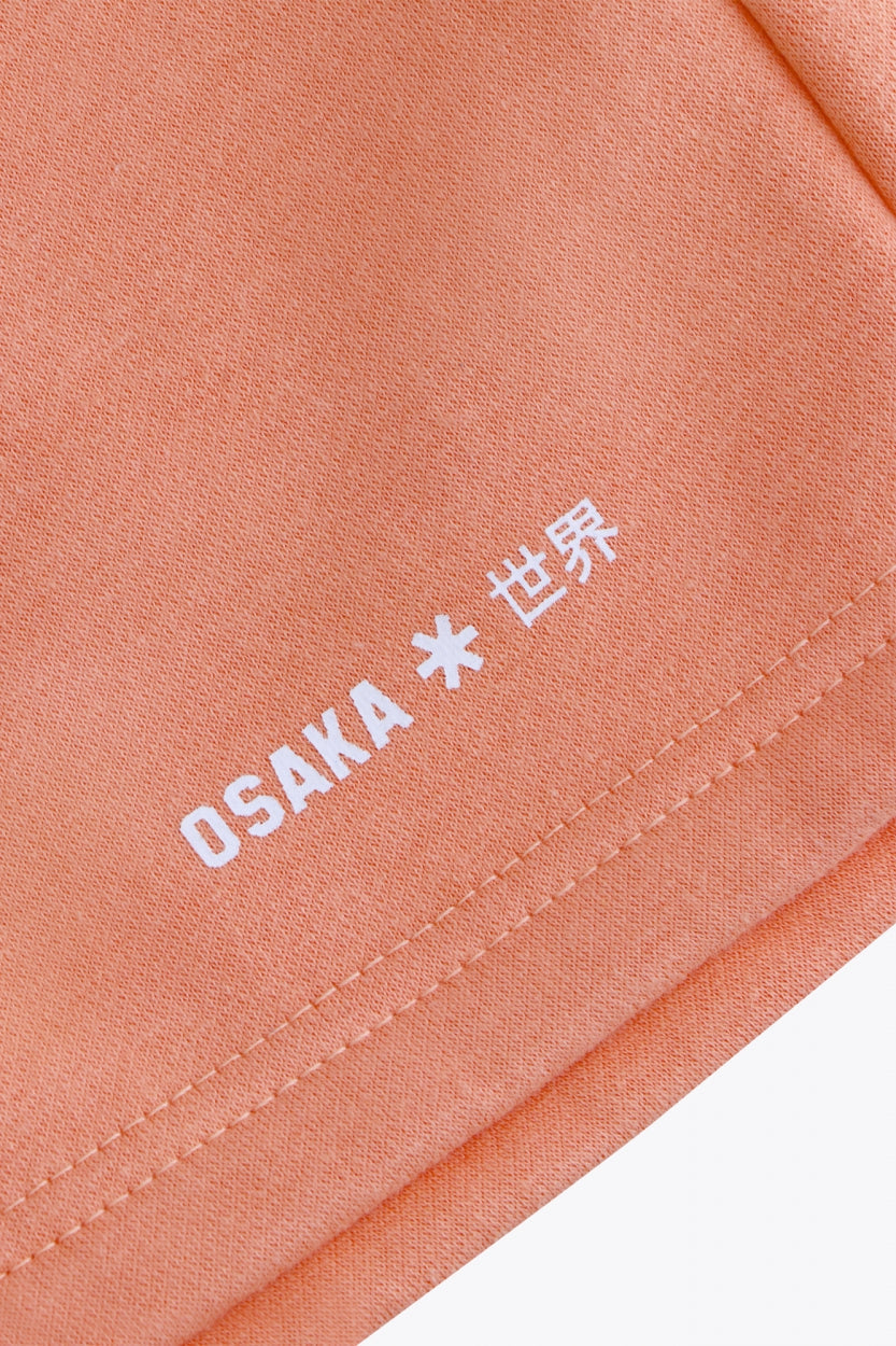 Osaka women shorts in peach with logo in white. Front flatlay detail logo view