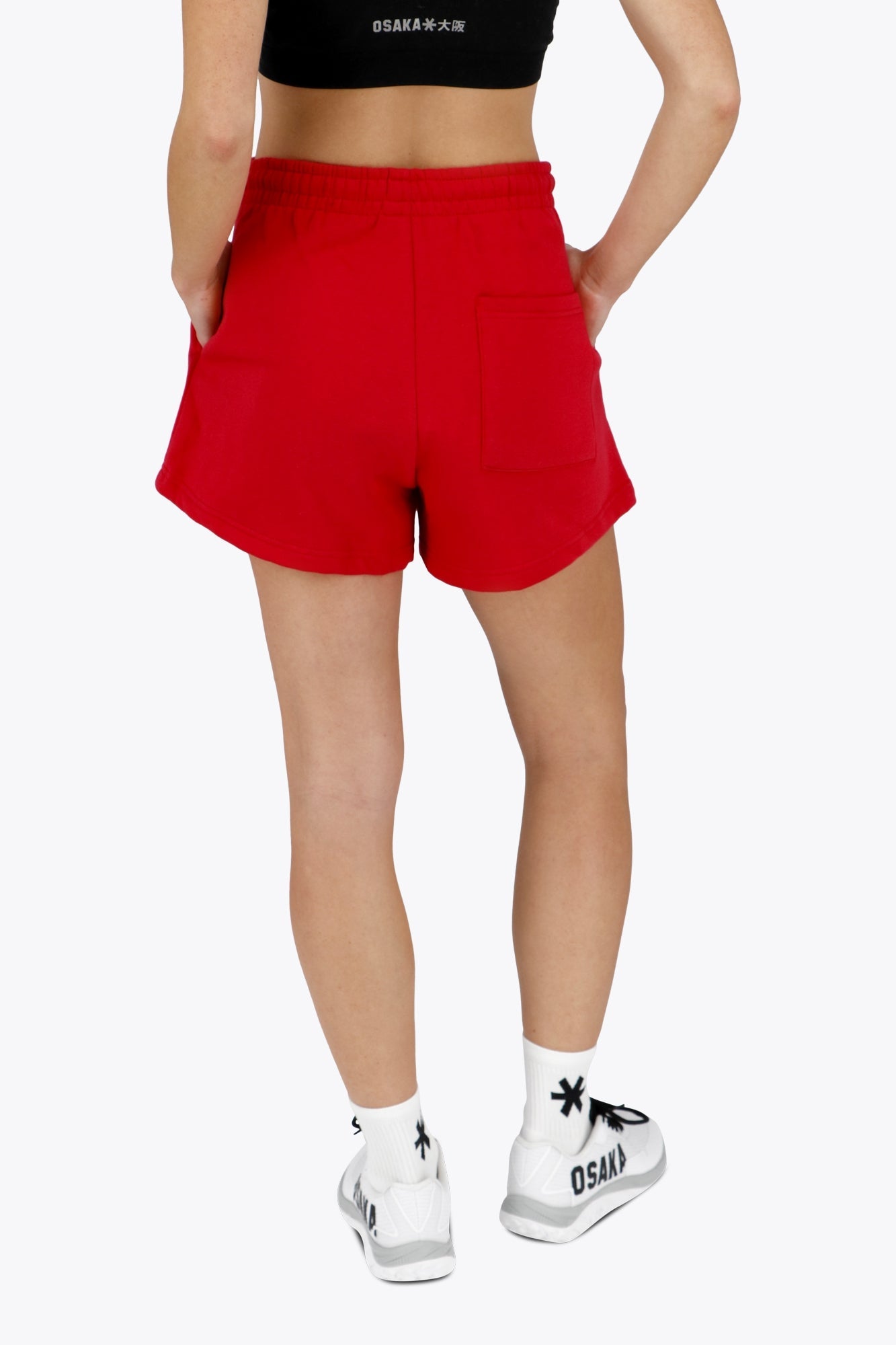 Woman wearing the Osaka women shorts in red with logo in white. Back view
