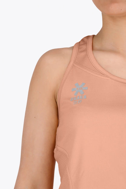 Woman wearing the Osaka women singlet in peach with logo in grey. Front logo view