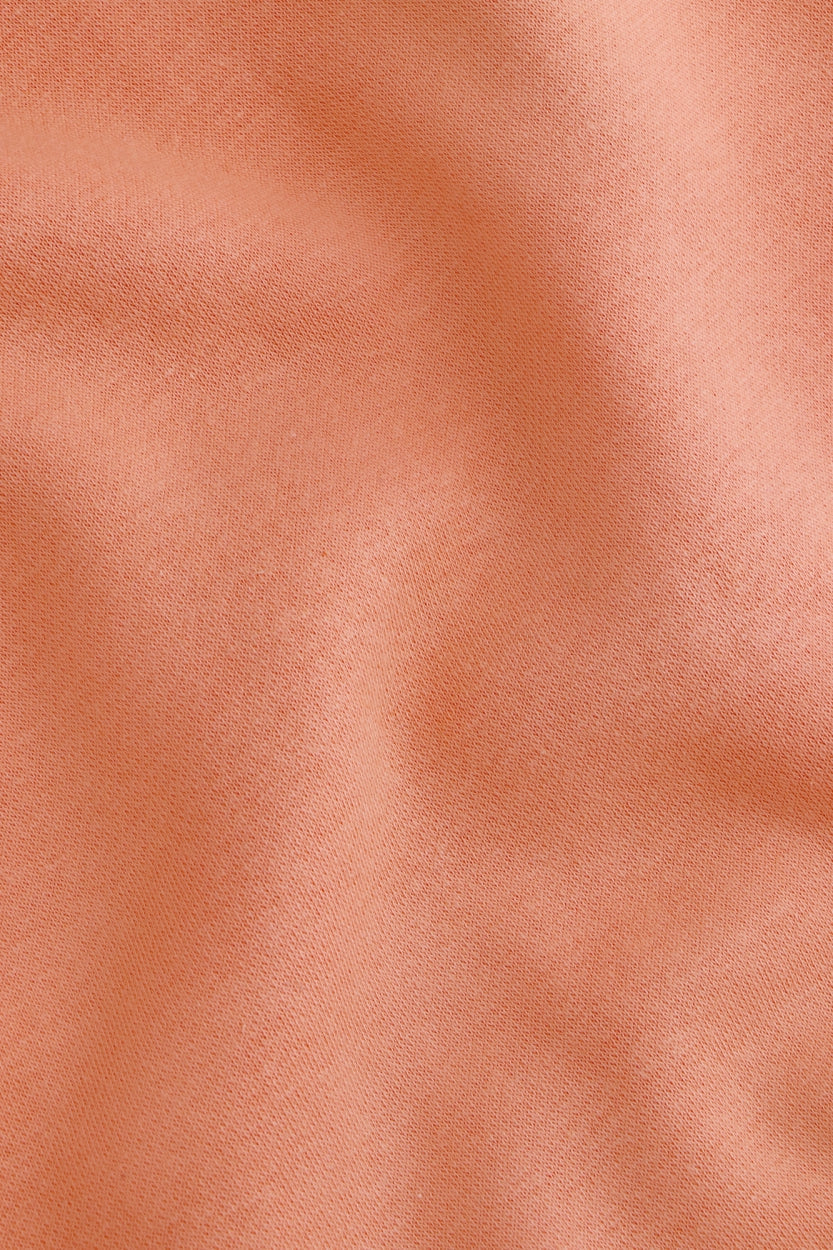 Osaka women sweater in peach with logo in white. Detail fabric view