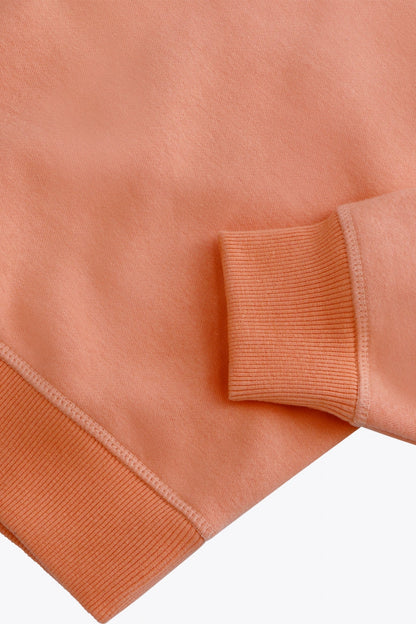 Osaka women sweater in peach with logo in white. Front flatlay detail sleeve view