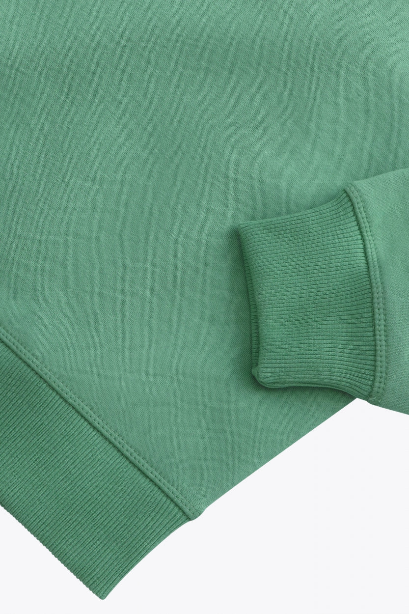 Osaka women sweater in green with logo in white. Front flatlay sleeve view