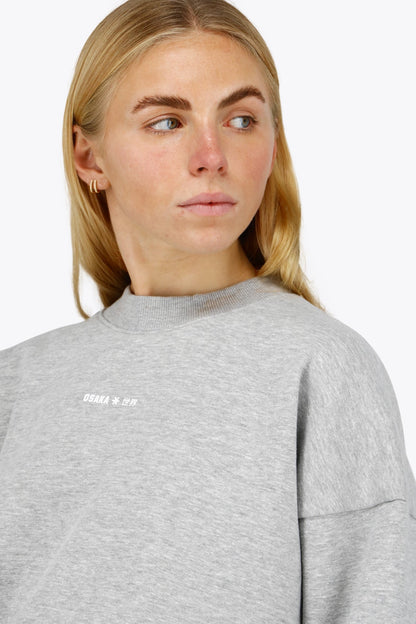 Osaka women sweater in heather grey with logo in white. Front detail logo view