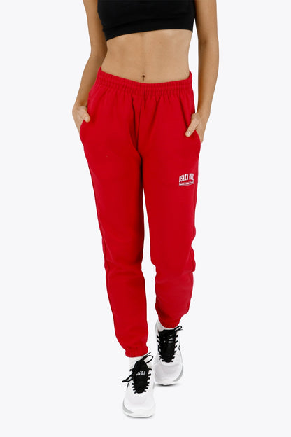 Woman wearing the Osaka women sweatpants in red with logo in white. Front view
