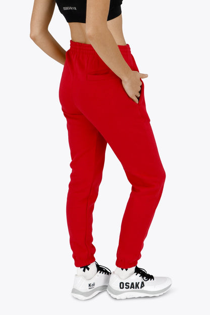 Woman wearing the Osaka women sweatpants in red with logo in white. Back view