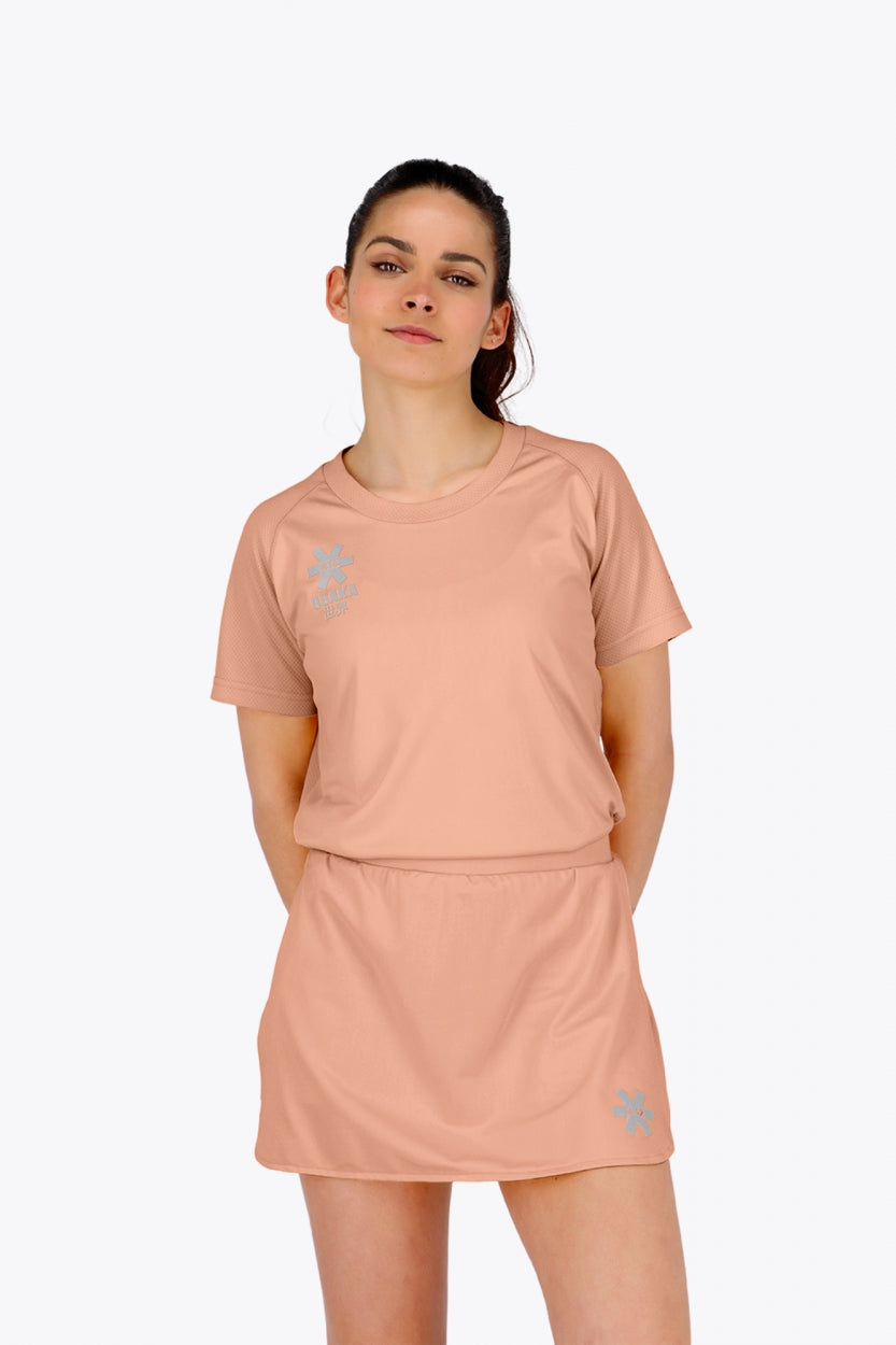 Woman wearing the Osaka women tee short sleeve in peach with logo in grey. Front view
