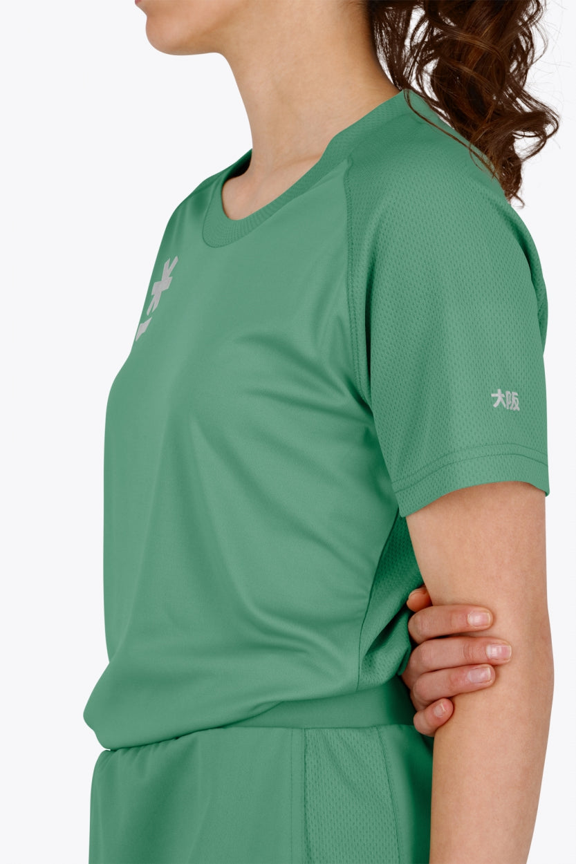 Woman wearing the Osaka women tee short sleeve in green with logo in grey. Side view
