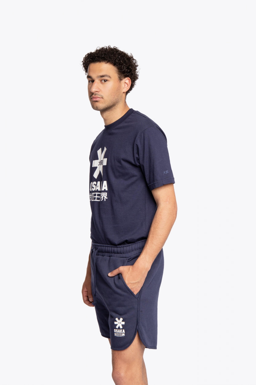 Man wearing the Osaka court classic short in navy with white logo. Side full view