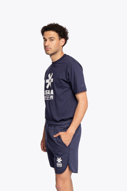 Man wearing the Osaka court classic short in navy with white logo. Side full view
