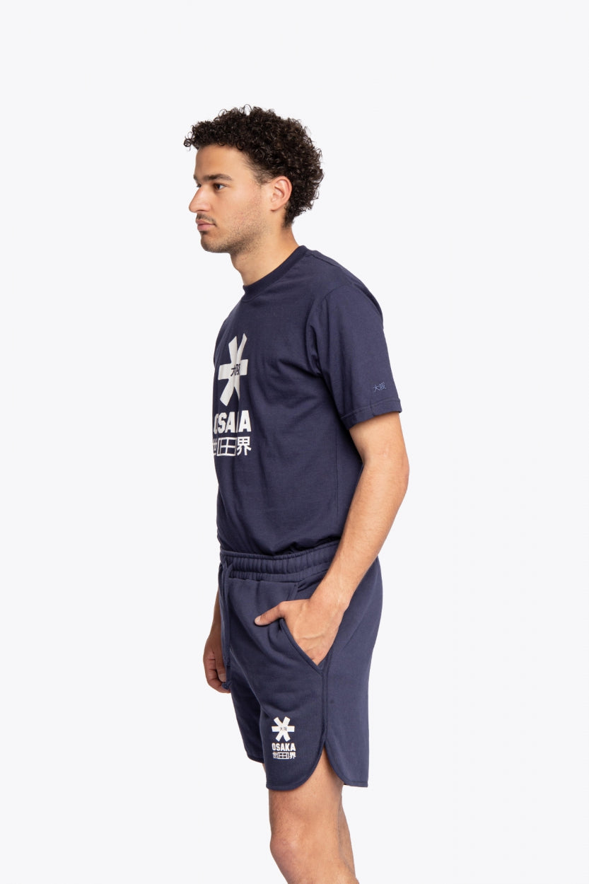 Man wearing the Osaka court classic short in navy with white logo. Side full view