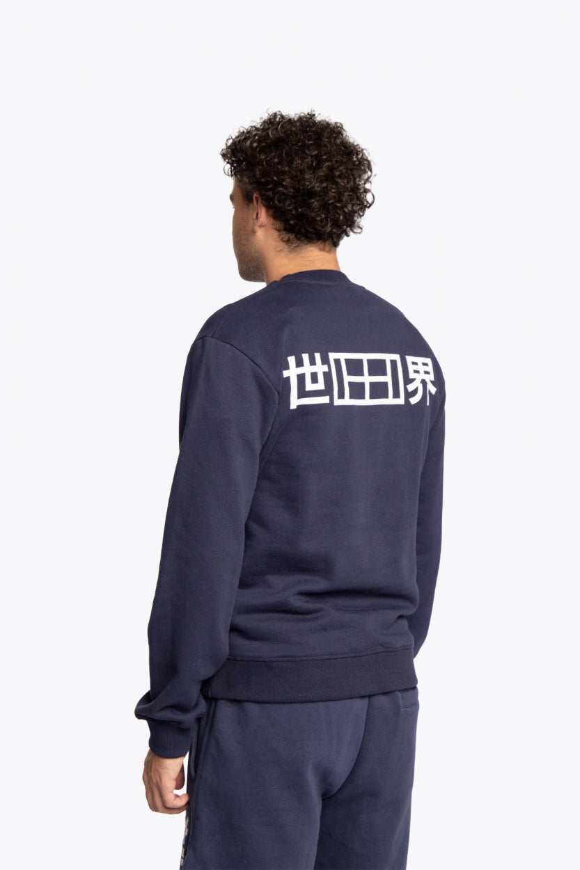 Man wearing the Osaka navy basic unisex sweater with logo in white. Back view
