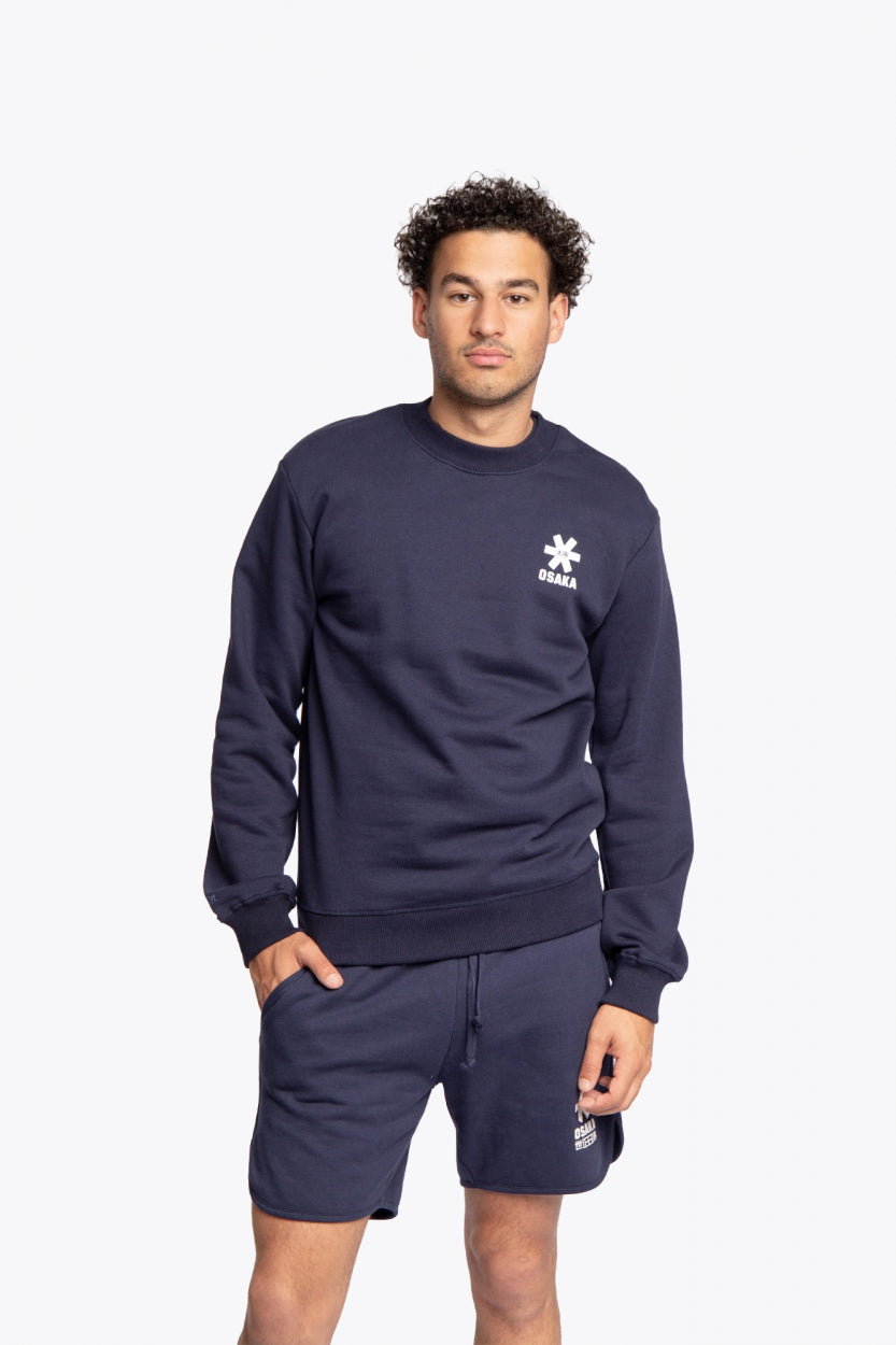 Man wearing the Osaka navy basic unisex sweater with logo in white. Front view