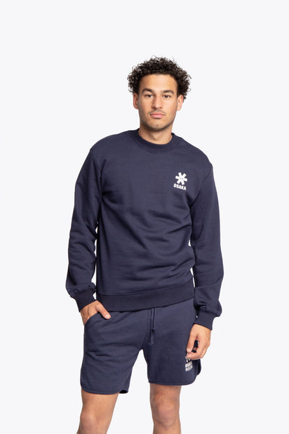 Man wearing the Osaka navy basic unisex sweater with logo in white. Front view