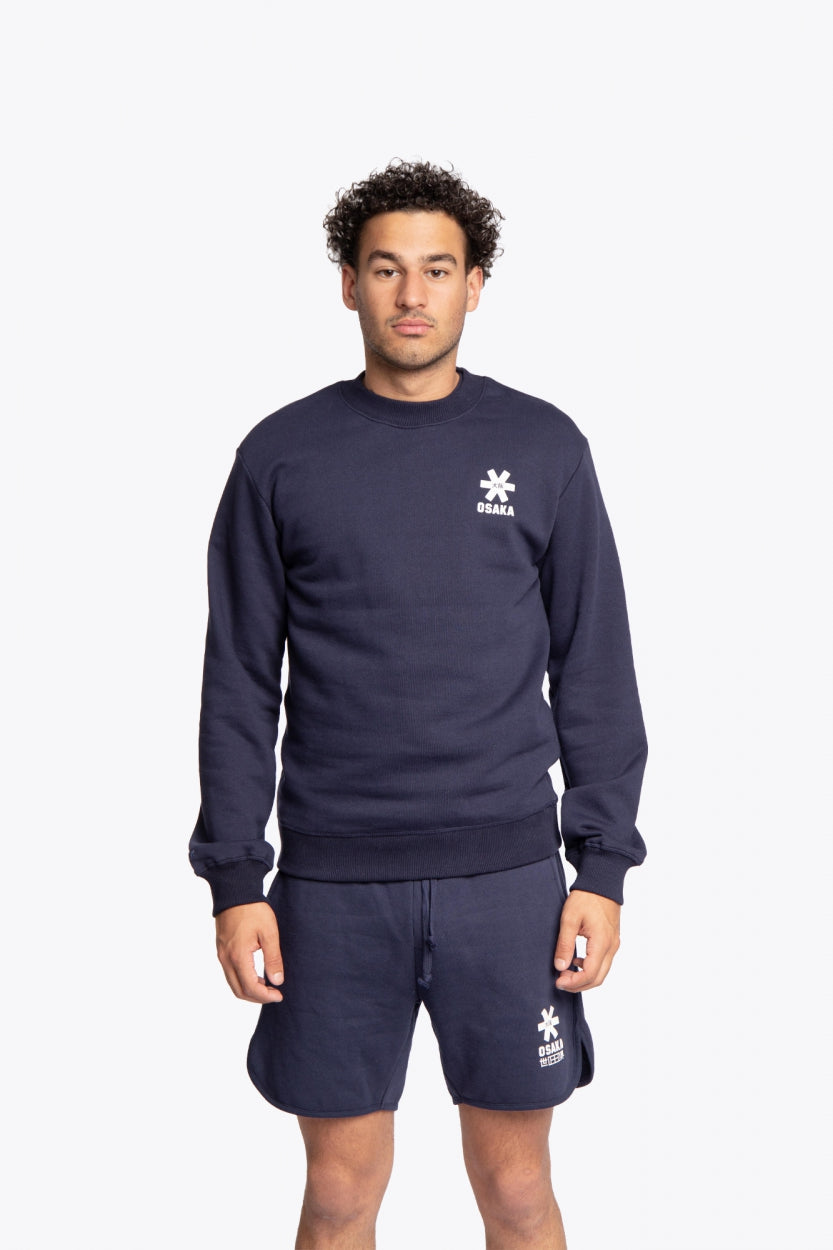 Man wearing the Osaka navy basic unisex sweater with logo in white. Front view